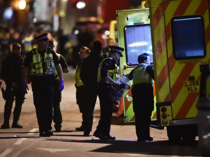 Police officers speak with ambulance personnel after an incident near London Bridge in London